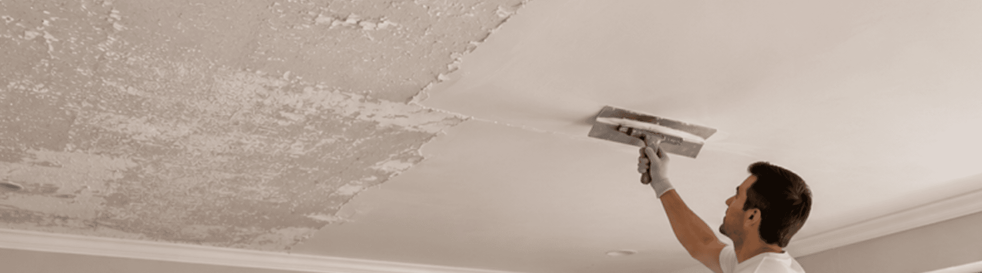 A tradesperson flattening a ceiling after texture removal.