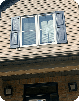 Second-floor window shutters painted in matching navy blue.